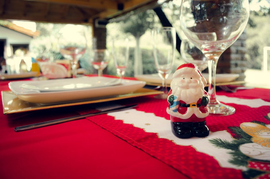 A cheerful Santa figurine decorates a festive table setting ready for a Christmas celebration.