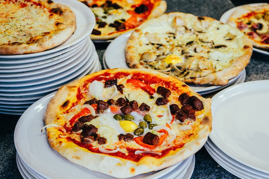 Delicious variety of gourmet pizzas elegantly presented on stacked plates, perfect for food lovers.