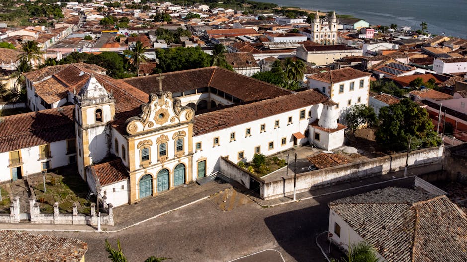 Aerial view of historic church and townscape in AL, Brazil, showcasing colonial architecture.