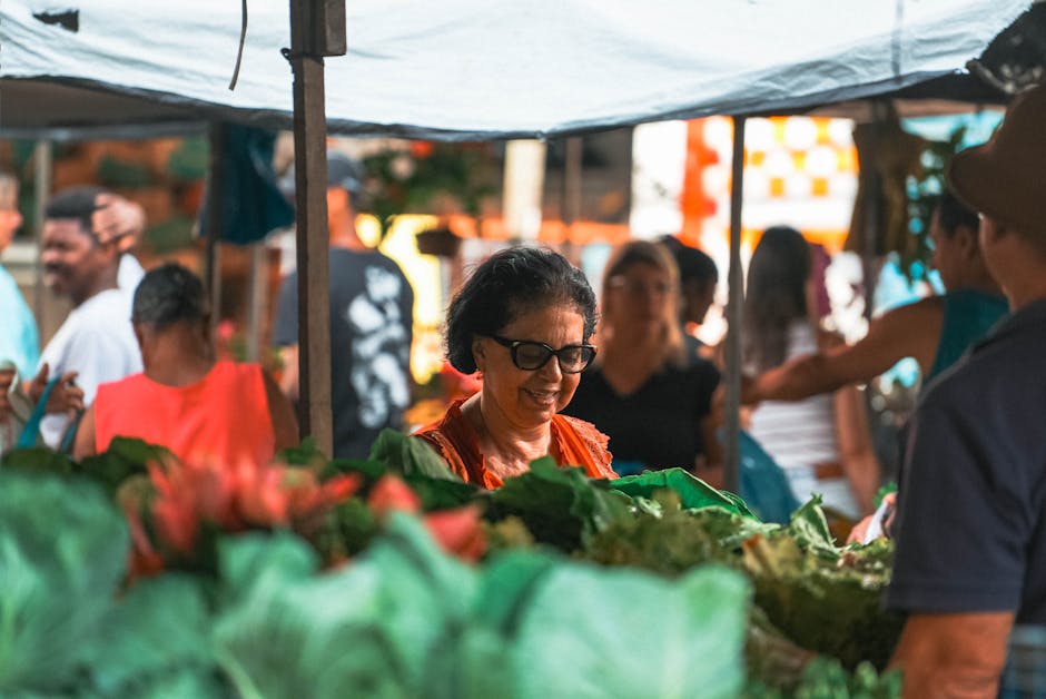 Senior woman exploring an outdoor market in Espírito Santo, Brasil, surrounded by fresh greens.