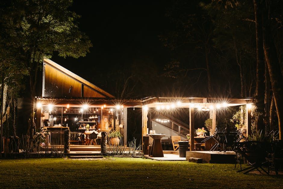 Cozy outdoor dining setting illuminated by warm lights on a summer night in Santa Teresa, Brazil.