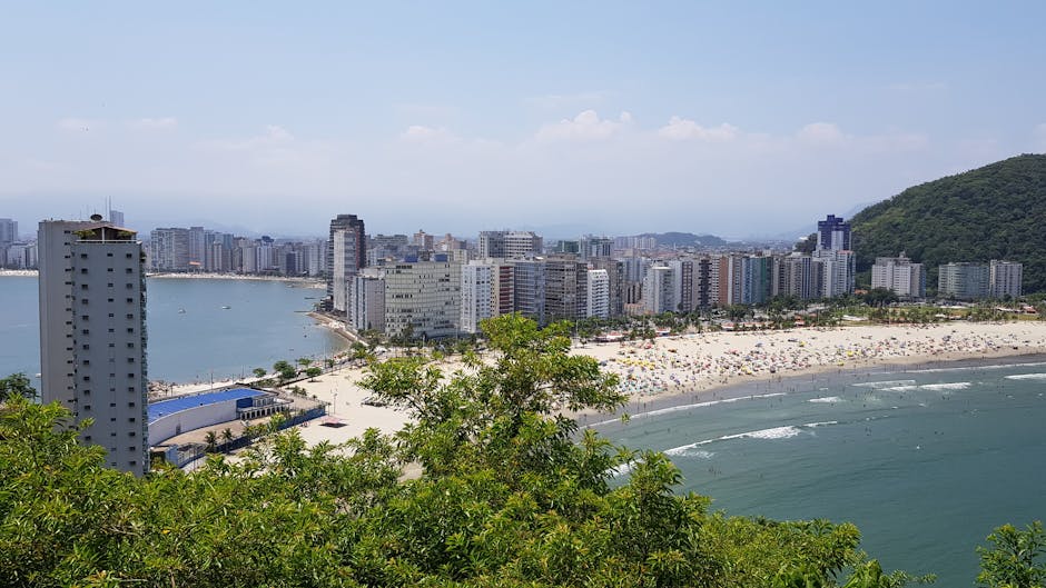 A vibrant cityscape with skyscrapers, beach, and ocean view on a sunny day.