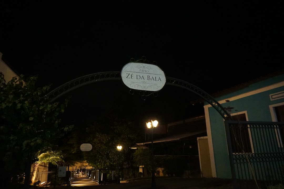 Archway with sign over a street at night