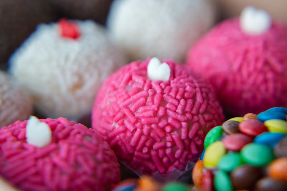 Close-up of colorful Brazilian brigadeiros with pink sprinkles, capturing a sweet treat's texture.