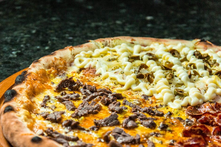 Delicious gourmet pizza with diverse meat and cheese toppings perfectly baked on a wooden board.