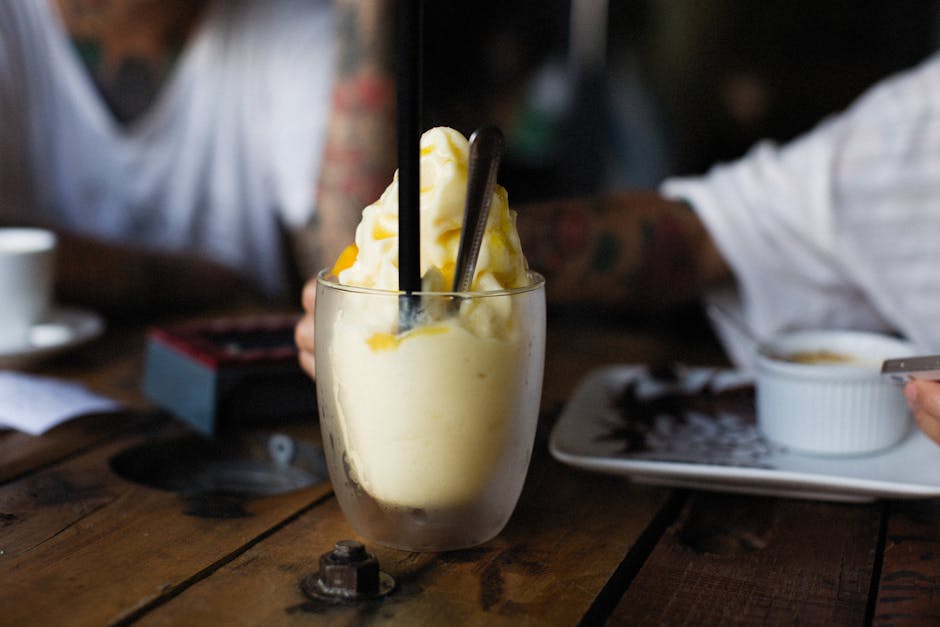 Creamy ice cream dessert with toppings served in a cafe setting, ideal for food photography.