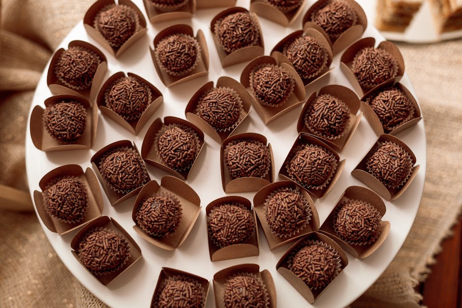 Delicious chocolate brigadeiros with sprinkles arranged on a platter, perfect for dessert catering events.