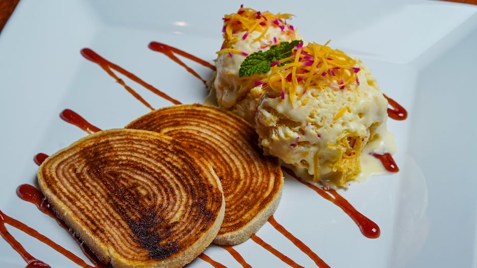 A deliciously presented gourmet dessert with ice cream, swirl toast, and decorative sauce.