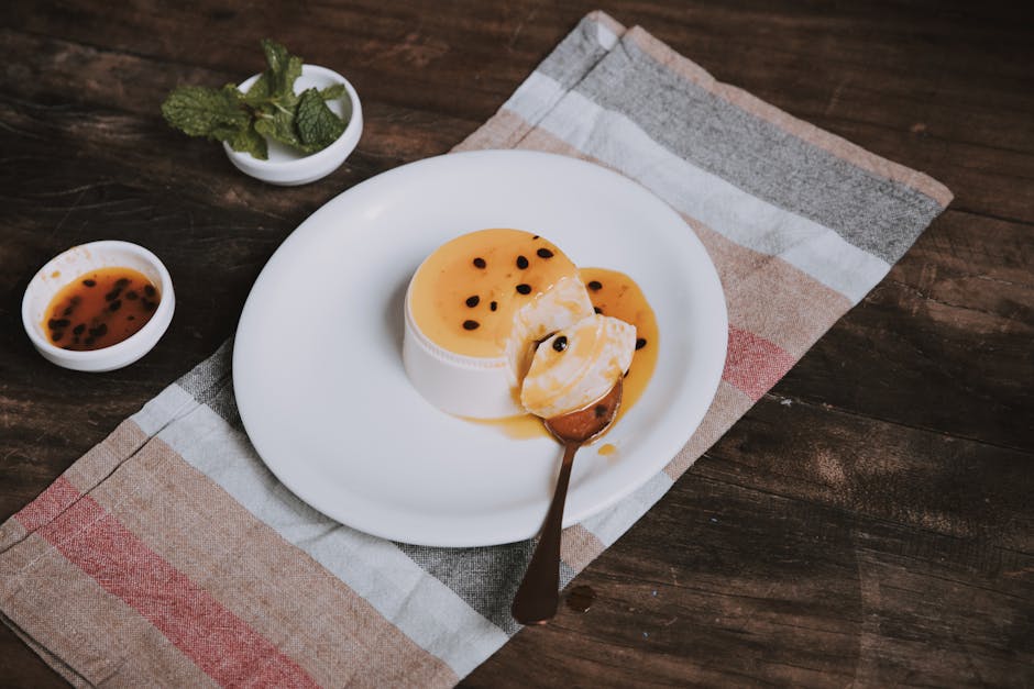 Delicious passion fruit flan garnished with seeds and mint on a rustic table setting, shot in São Paulo, Brazil.