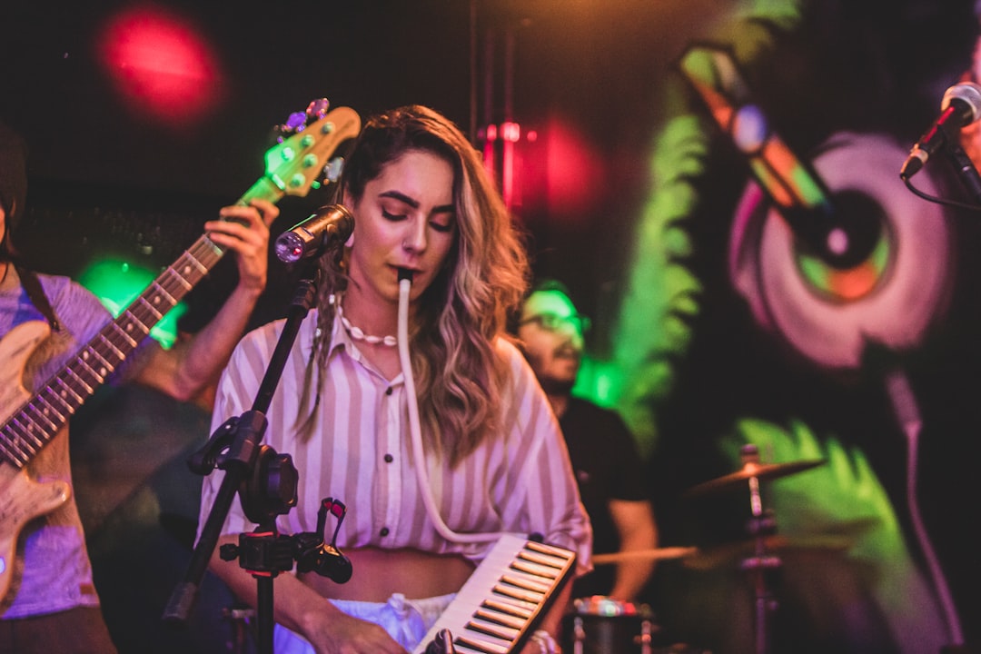 a woman playing a musical instrument in front of a microphone