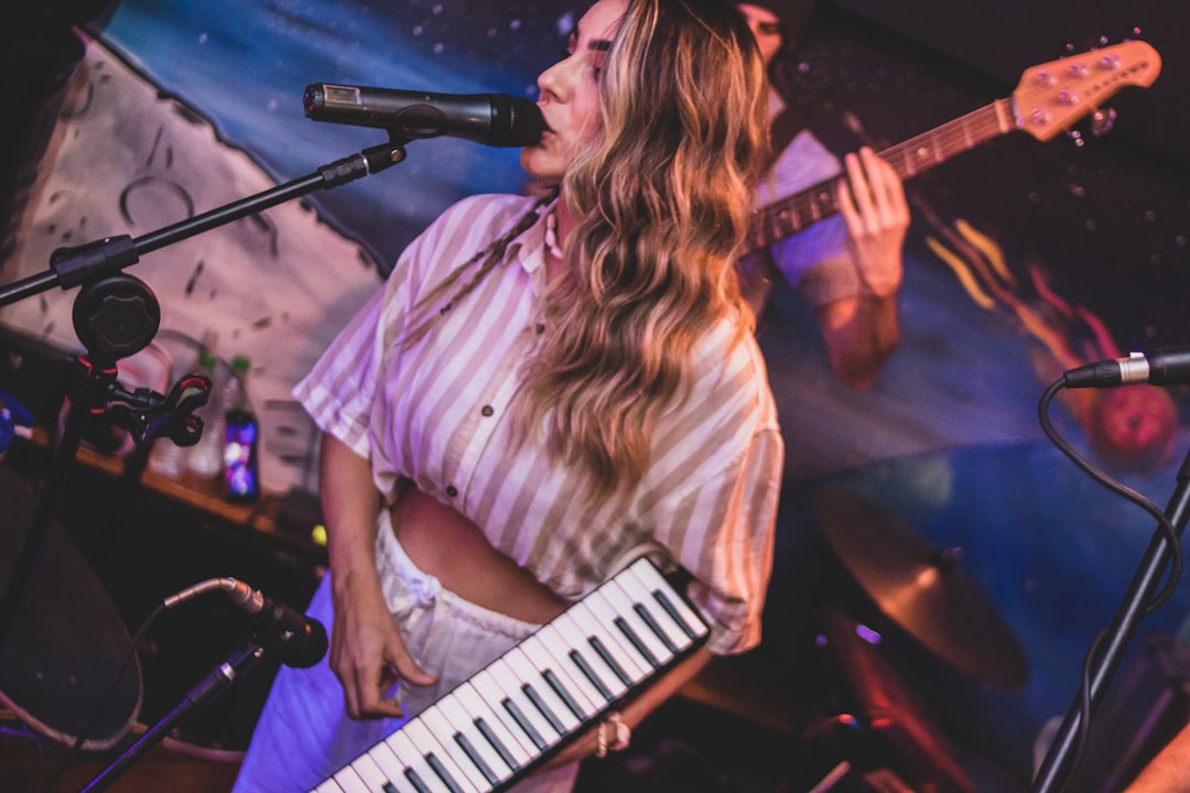 a woman playing a keyboard in front of a microphone