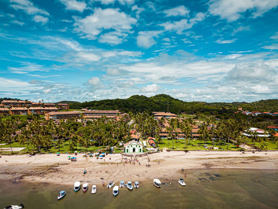 an aerial view of a beach with boats in the water