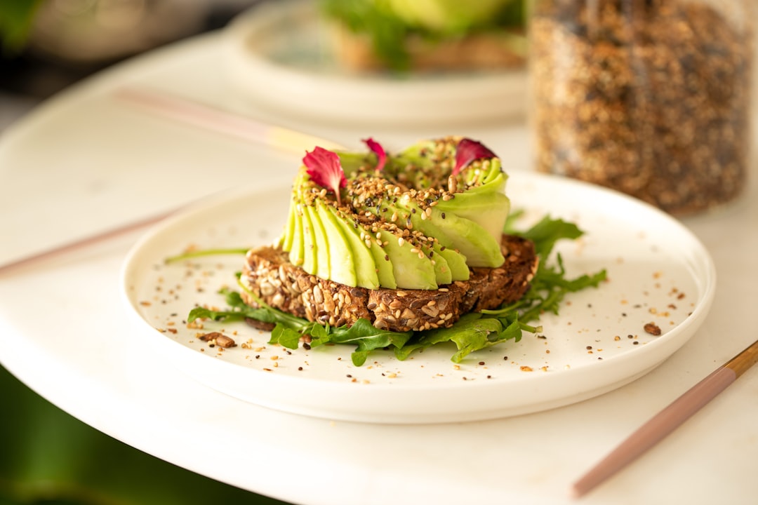 a white plate topped with an avocado sandwich