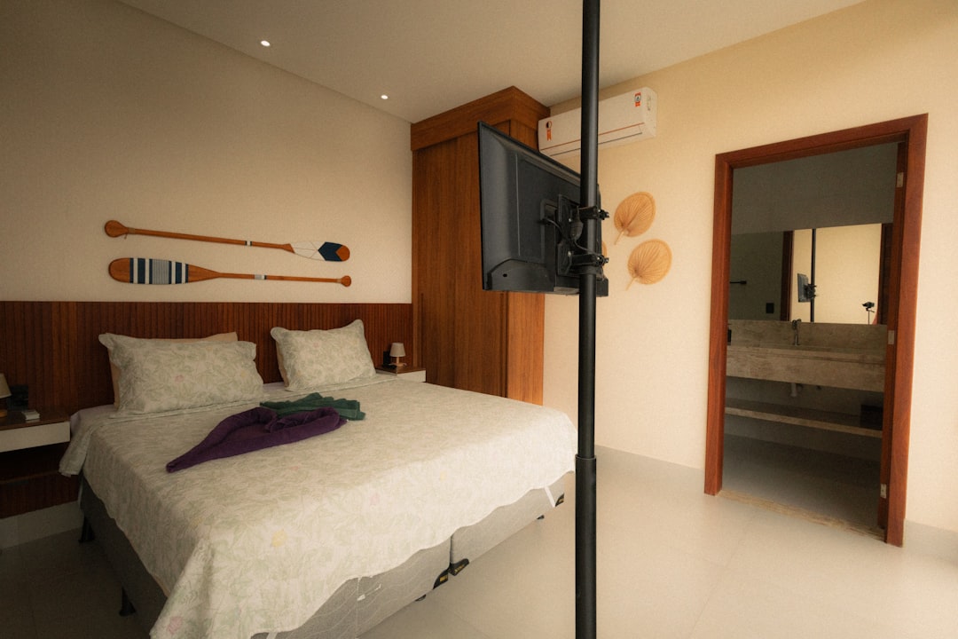 Bedroom with bed, television, and open doorway to bathroom.