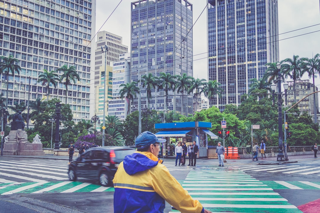 man wearing yellow and blue raincoat near street during daytime
