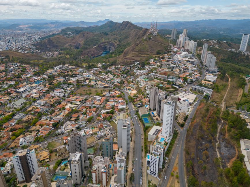 Stunning aerial view of Belo Horizonte cityscape with surrounding mountains under a cloudy sky.