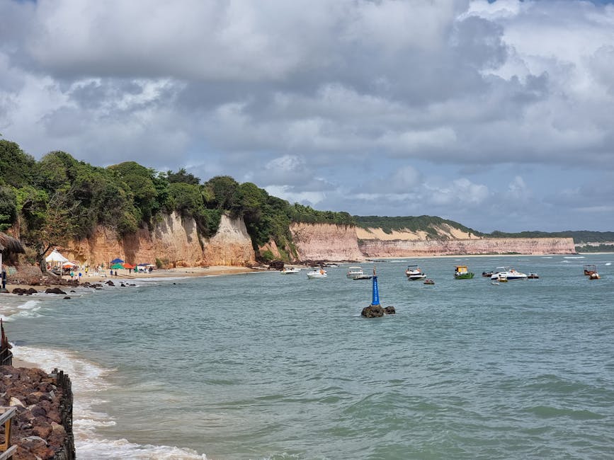Beautiful coastal scene with cliffs and boats at Pipa beach in Brazil.