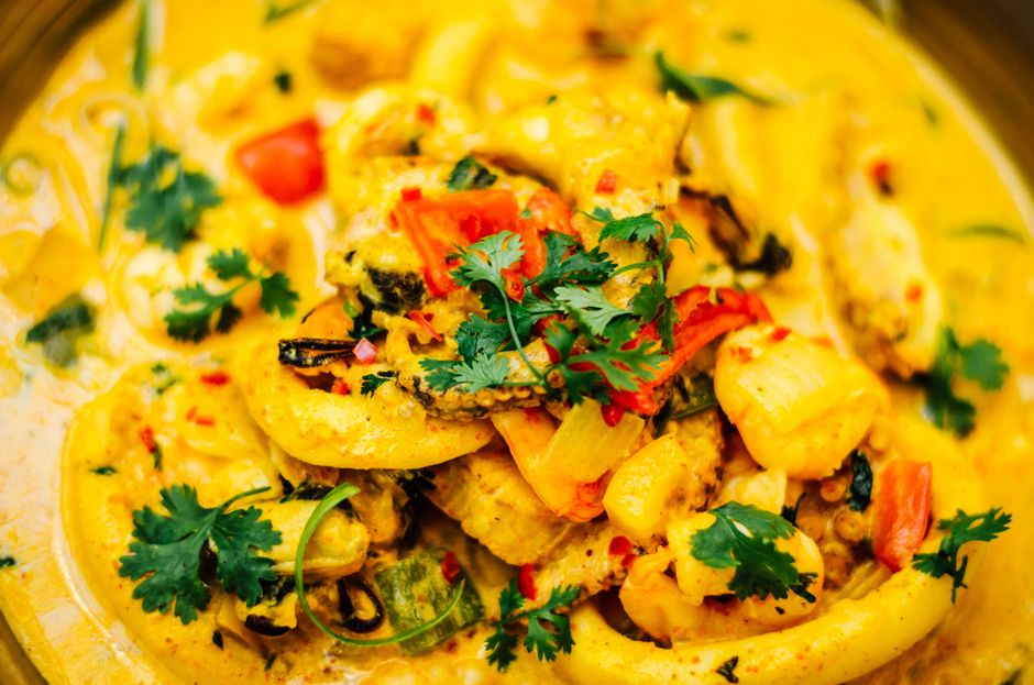 A vibrant close-up of a delicious Brazilian seafood curry dish garnished with fresh herbs.