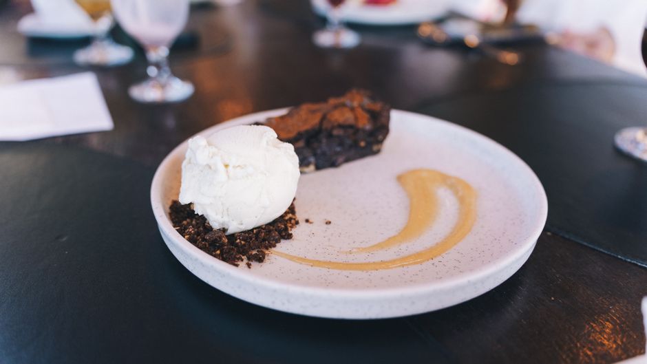 Close-up of a gourmet dessert featuring vanilla ice cream and brownie on a stylish plate.